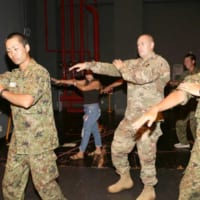 迷彩服姿で踊る自衛隊員とアメリカ兵