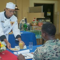 「シェフ・オブ・ザ・クォーター」で審査員に料理を提供するカーター・ハーディ2世上等兵（Image：USMC）