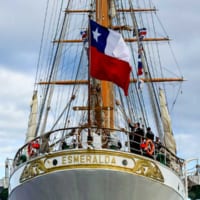 チリ国旗はためく船尾で手を振るエスメラルダ乗組員（Image：Royal Australian Navy, Commonwealth of Australia 2019）
