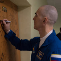 コスモノートホテルのドアにサインを記すイヴァニシン宇宙飛行士（Image：ロスコスモス）