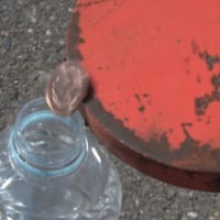 ツメに乗せた10円玉を「そーっと」ペットボトルの口に近づけ、大きさギリギリの穴にイン