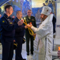 ロシア連邦軍大聖堂での戦没者追悼ミサでキャンドルに火を灯す司祭（Image：ロシア国防省）