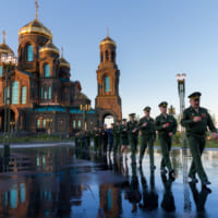 キャンドルを手に聖堂を退出する参加者（Image：ロシア国防省）