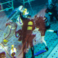 バイザー越しに宇宙飛行士の様子を確認するダイバー（Image：ロスコスモス）