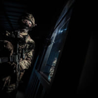 窓から外を窺うイギリス海兵隊員（Image：Crown Copyright 2020）
