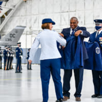 ラーン氏から新しい上着を着せてもらうバス空軍最先任上級曹長（Image：USAF）