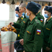 民族衣装の女性からパンを受け取る（Image：ロシア国防省）