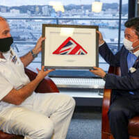 イギリス軍艦旗（ホワイト・エンサイン）を贈られる岸防衛大臣（Image：Crown Copyright）